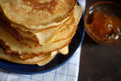 Stack of pancakes with maple syrup on table