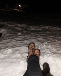 Low section of man standing on snow