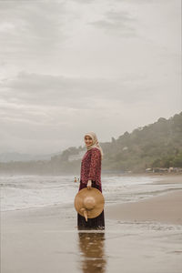 Woman on beach against sky