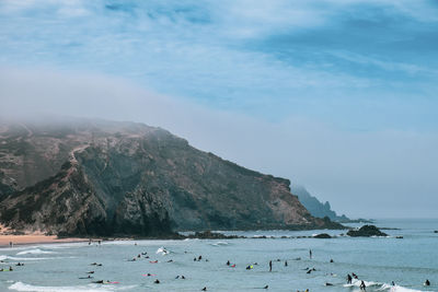 Scenic view of sea and mountains against sky