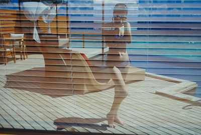 Reflection of woman in bikini on window