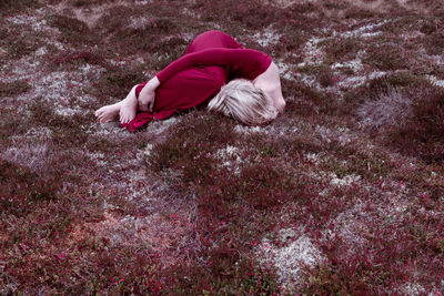 Man lying on red umbrella