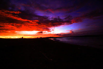 Scenic view of sea against dramatic sky during sunset