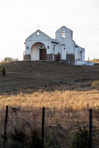 Abandoned building on field against sky