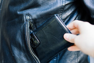 Midsection of man holding wallet