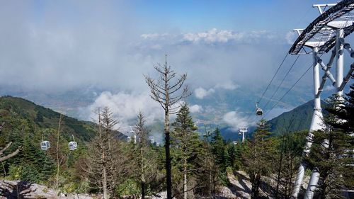 Low angle view of overhead cable car against sky