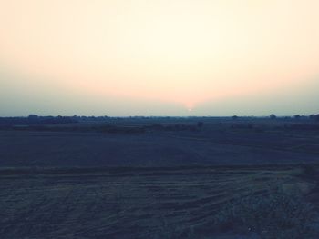 Scenic view of field against clear sky during sunset