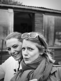 Portrait of happy friends standing against house