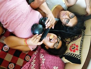 High angle view of sisters lying on bed at home