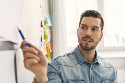 Confident mid adult businessman giving presentation in office