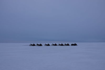 Scenic view of snowbike on sea against clear sky