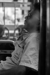 Side view of young man while sitting in bus 