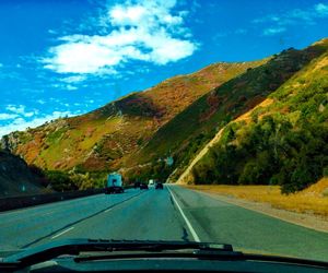 Car on road amidst mountains against sky