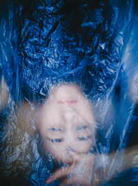 High angle view of woman lying under plastic