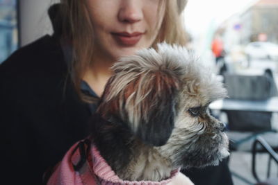 Midsection of woman with dog at cafe 