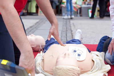 Midsection of person performing cpr on dummy