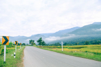 Empty road along landscape against sky