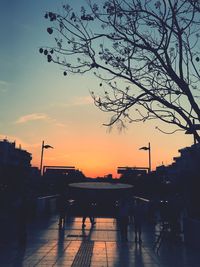 Silhouette trees and buildings against sky during sunset