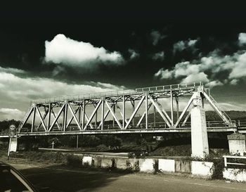 Bridge over river against cloudy sky