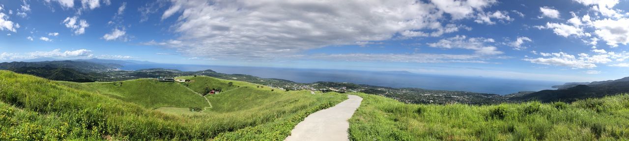 cloud - sky, beauty in nature, scenics - nature, tranquil scene, sky, environment, tranquility, plant, landscape, green color, non-urban scene, nature, land, mountain, grass, road, panoramic, day, no people, idyllic, outdoors