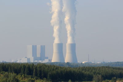 Smoke emitting from chimney against sky