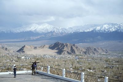 Rear view of people on snowcapped mountains against sky