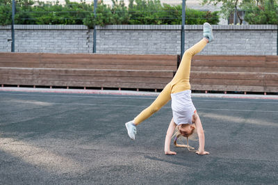 Full length of woman exercising on field