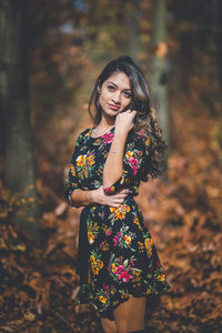 Beautiful young woman standing against blurred background