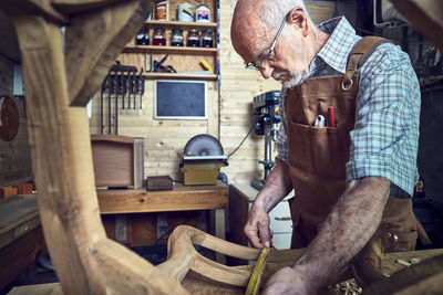 Side view of senior man working in workshop