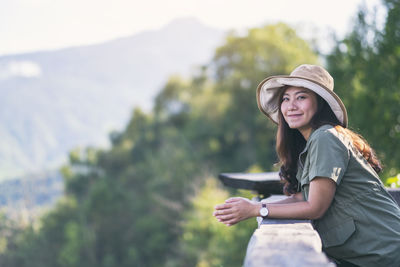 Portrait of smiling woman wearing hat while standing at observation point