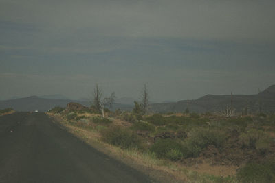 Road by mountain against sky