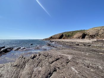 Scenic view of beach against clear blue sky