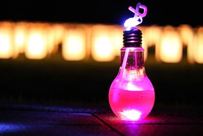 Close-up of illuminated light bulb on table