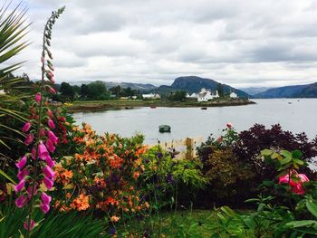 Scenic view of lake and mountains against cloudy sky