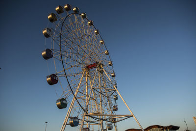 Low angle view of ferris wheel against clear sky