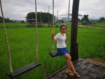 Full length portrait of woman sitting on swing