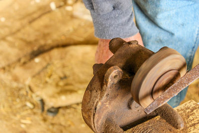 Cropped image of worker with rusty grinder