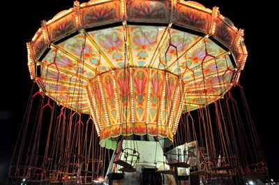 Low angle view of illuminated ferris wheel against sky at night