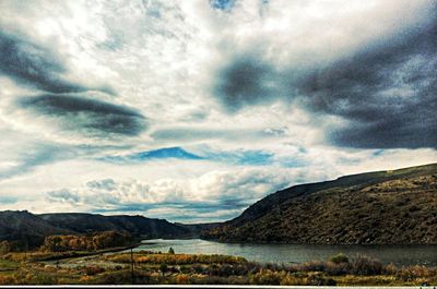 Scenic view of mountains against cloudy sky