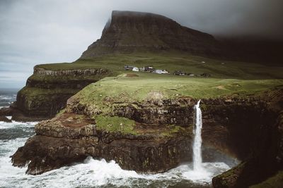 Scenic view of waterfall against sky