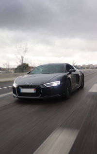 Car on road against cloudy sky