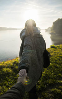 Rear view of woman on shore against sea