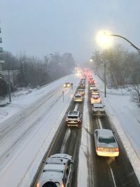 Cars on snow covered road in city