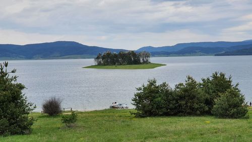 Scenic view of sea and mountains against sky