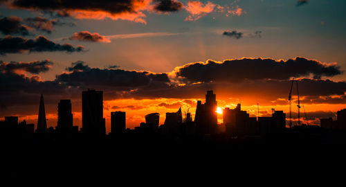 Silhouette buildings against sky during sunset
