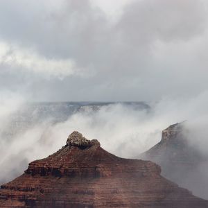 Scenic view of clouds over mountain against cloudy sky