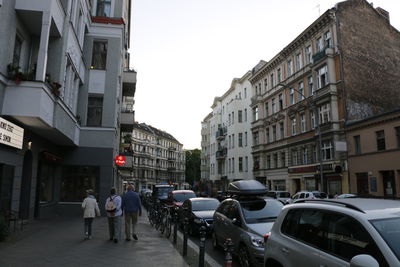 People on street amidst buildings in city