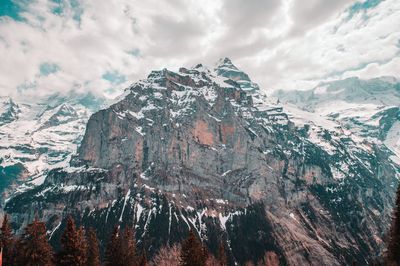 Scenic view of snowcapped mountains against cloudy sky