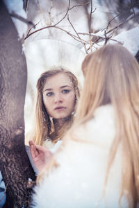 Portrait of young woman with tree