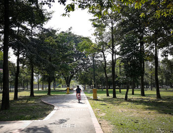 A kid is cycling in the park